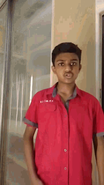 a young boy wearing a red shirt that says titans