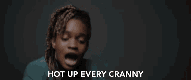 a woman in a green jacket says " hot up every cranny " in front of her