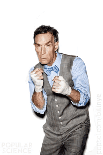 a man wearing boxing gloves and a blue bow tie stands in front of a white background with popular science written on it
