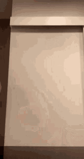 a white wall with a shelf on the side of it