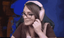 a woman wearing glasses and headphones is sitting in front of a blue background .
