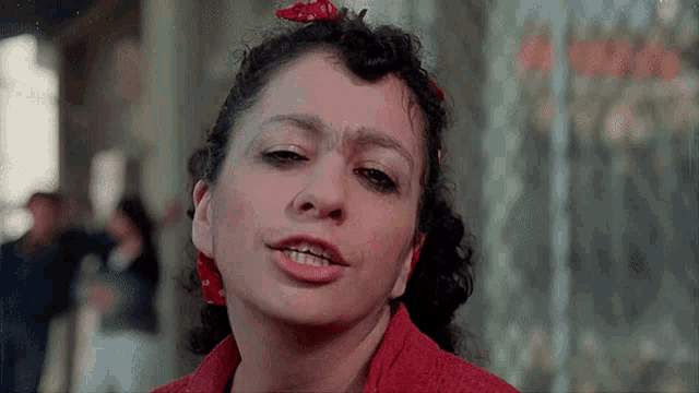 a woman wearing a red shirt and a red bow in her hair