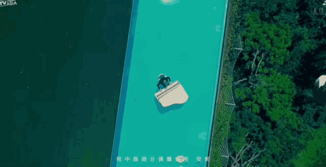 an aerial view of a person floating on top of a swimming pool