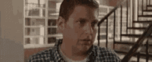 a man in a plaid shirt is standing next to a set of stairs .