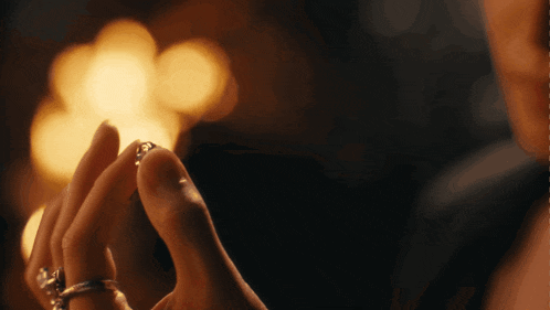 a close up of a woman 's hands with rings on