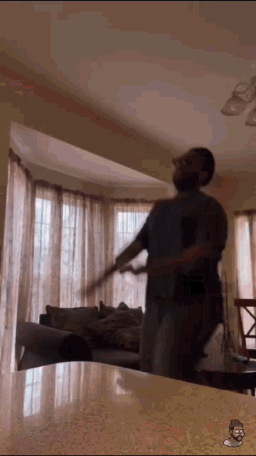 a man is dancing in a living room with a cartoon of a man on the counter