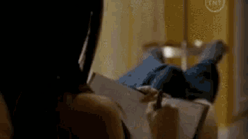 a woman is laying on her stomach writing in a notebook .