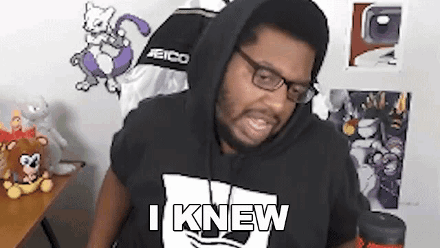 a man wearing a black hoodie and glasses is making a funny face .