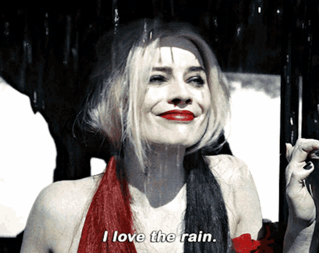 a woman in a red and black dress is smiling and says i love the rain