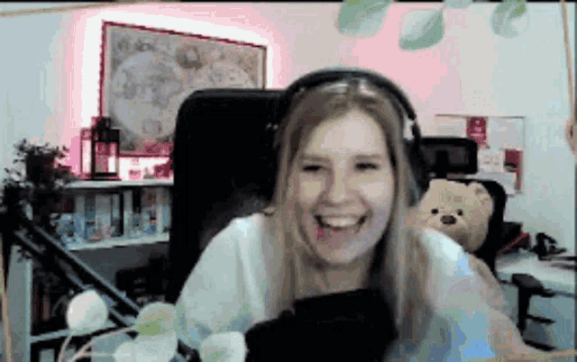a woman wearing headphones is sitting in a chair and smiling .