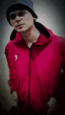 a man wearing a beanie and a red jacket with the letter p on the front