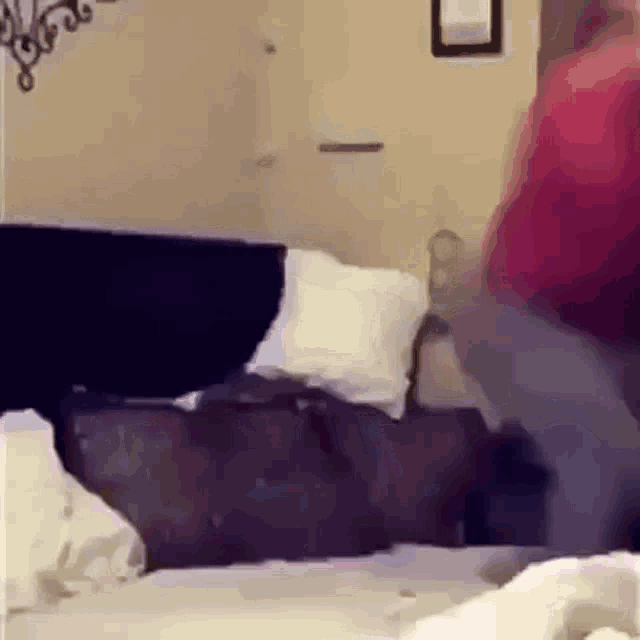 a person is standing on a bed in a room with a couch .