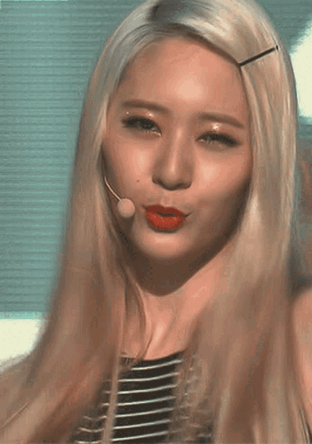 a close up of a woman 's face with long blonde hair