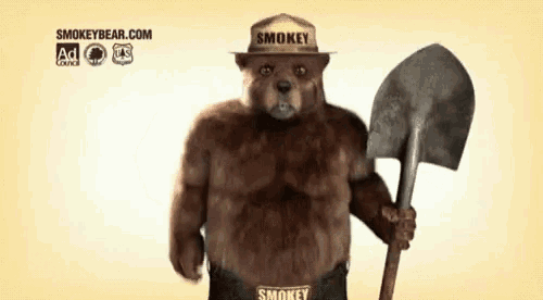 smokey bear holding a shovel and wearing a smokey hat