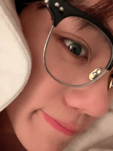a close up of a person 's face wearing glasses and a hat