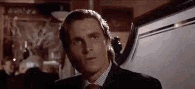 a close up of a man in a suit and tie looking at the camera .