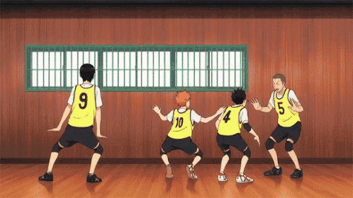 a group of volleyball players are doing a dance in a gym .