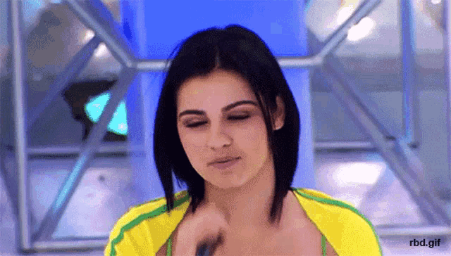 a gif of a woman in a yellow and green shirt with the words rbd.gif at the bottom