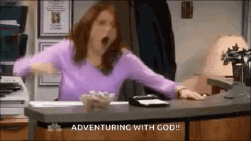 a woman is yawning while sitting at a desk with her mouth open .