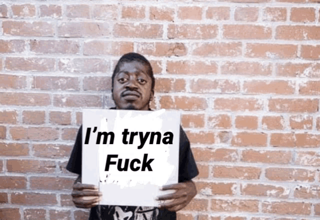 a man is holding up a sign that says i 'm tryna fuck