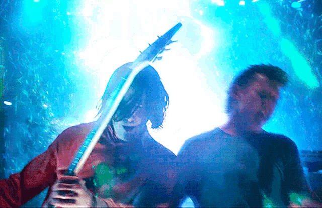 a man in a red shirt is playing a guitar