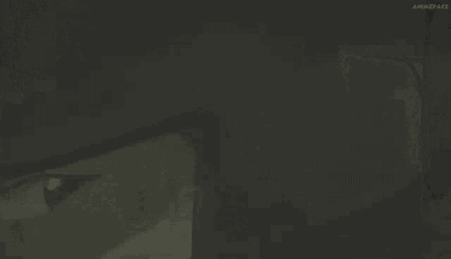 a person is standing in a foggy room with a light coming out of the ceiling .