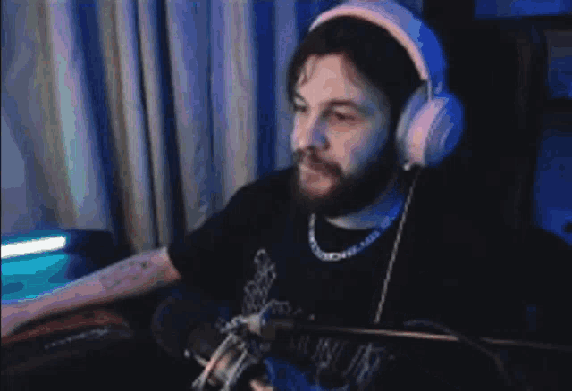a man wearing headphones is holding a cell phone