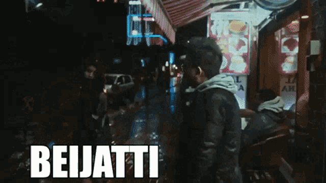 a man in a black jacket stands in front of a store that says beijatti