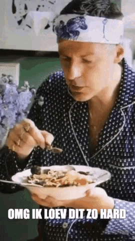 a man with a bandana on his head is eating a bowl of food with the words omg ik loev dit zo hard below him