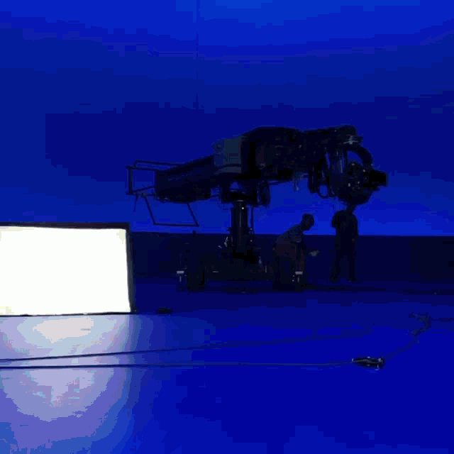 a man wearing a mask and goggles is laying on his back on a blue background