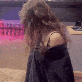 a woman with long hair is standing in front of a counter