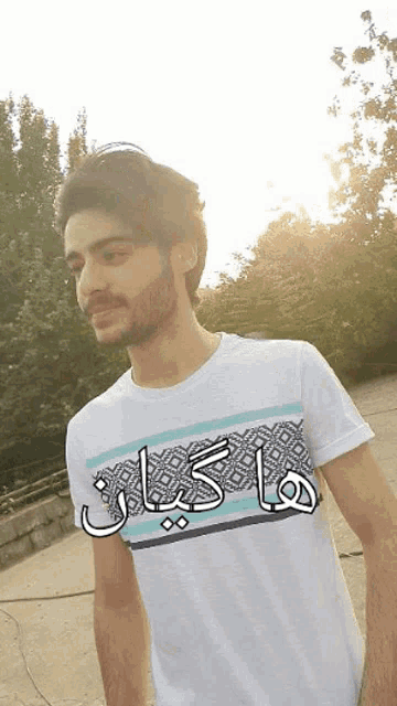 a man wearing a white t-shirt with arabic writing