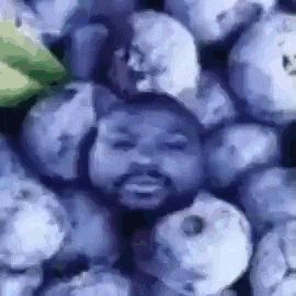 a pile of blueberries with a man 's head in the middle .
