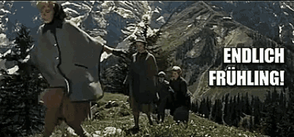 a group of people standing on top of a hill with the words endlich frühling written on the bottom