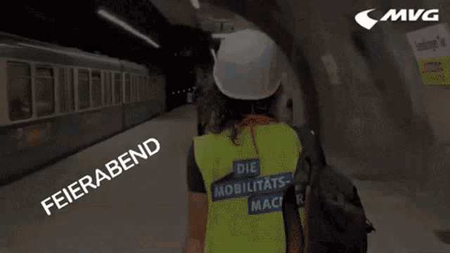 a woman wearing a hard hat and a yellow vest that says die mobilitats-mac on it