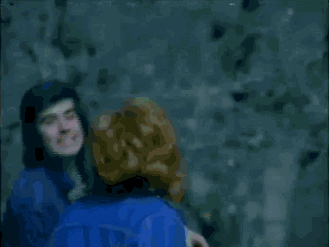 a blurry picture of a woman in a blue jacket crawling on the ground