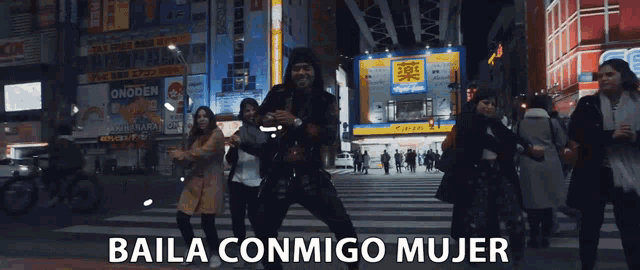 a group of people dancing on a street with the words baila conmigo mujer