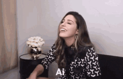 a woman is laughing while sitting on a couch .