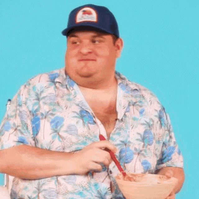 a man wearing a hat and a hawaiian shirt is eating cereal with a spoon .