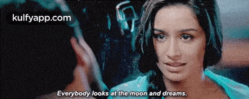 a woman is looking at a man with the words everybody looks at the moon and dreams .