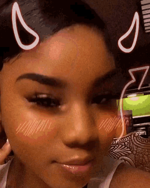 a close up of a girl 's face with devil horns on it