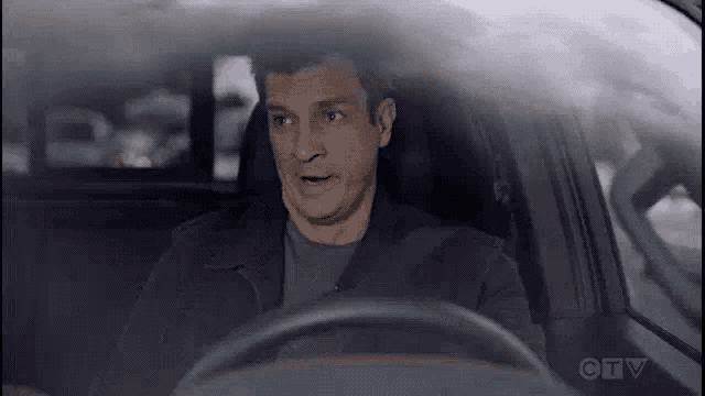 a man is driving a car with his mouth open and making a funny face .