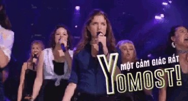 a woman singing into a microphone with yomost written on the bottom