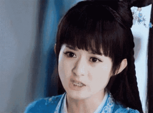 a close up of a woman 's face with a blue dress on .