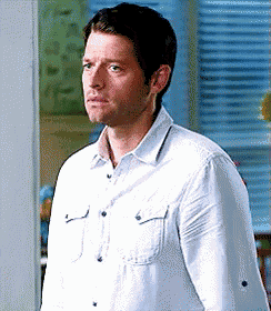 a man in a white shirt is standing in front of a window and making a funny face .