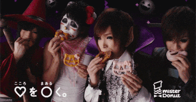 a group of people are eating donuts with the word mister donut in the corner