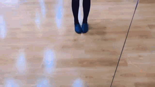 a woman in a plaid skirt and black knee high socks is standing in front of a mirror .