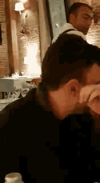 a man is sitting at a table with his eyes closed