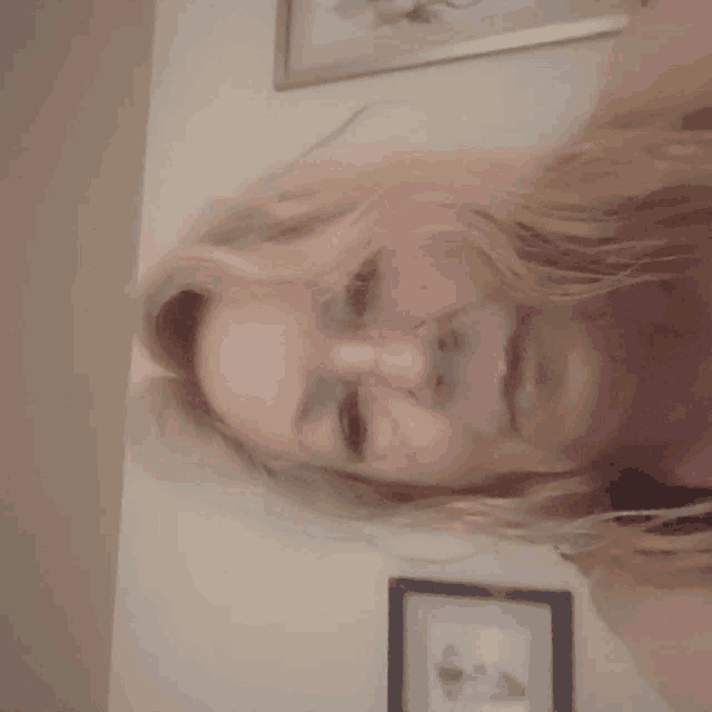 a woman is taking a selfie in front of a framed picture