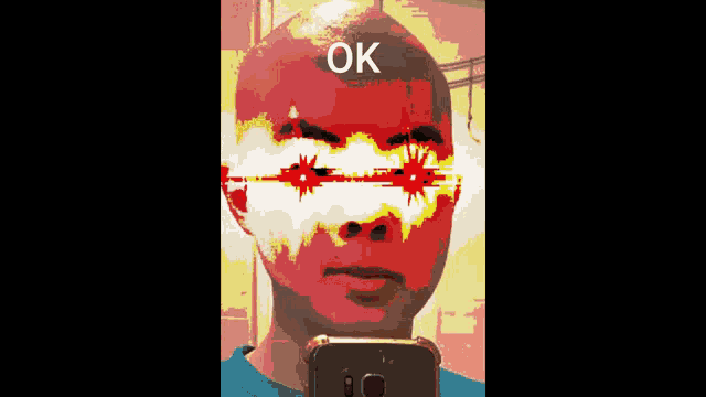 a man taking a picture of himself with the word ok on his face